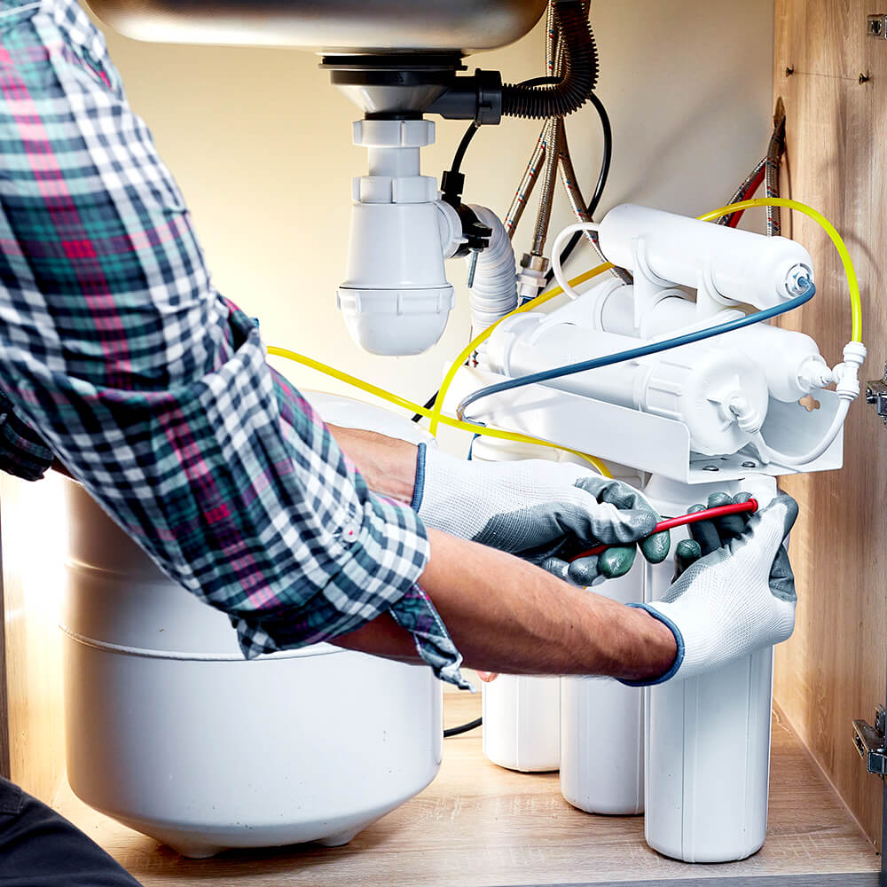 water treatment dealer installing residential water treatment product under sink